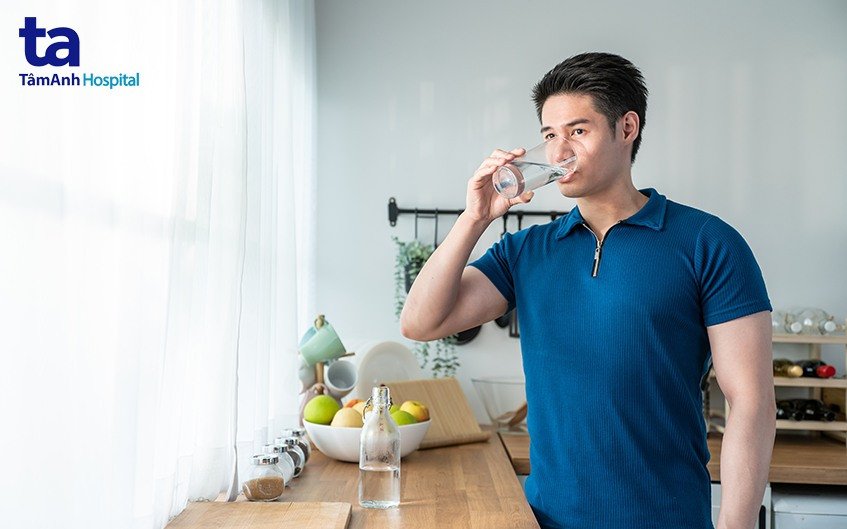 Người phụ nữ uống nước và ăn trái cây tươi, biểu tượng cho lối sống lành mạnh.