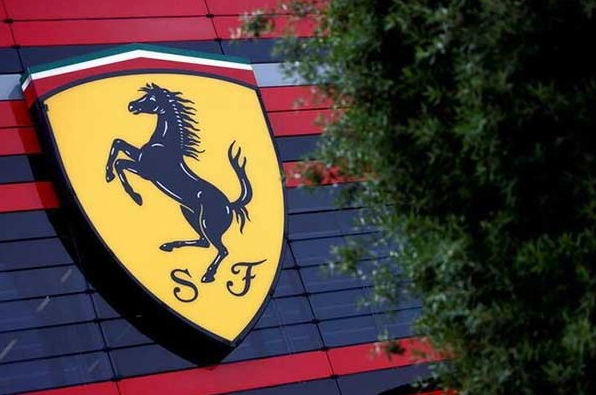 Logo Ferrari bên cạnh một chiếc xe Ferrari